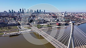 Aerial view of Warsaw current urban landscape on bank of Vistula and Swietokrzyski Bridge over river on sunny day