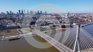 Aerial view of Warsaw current urban landscape on bank of Vistula and Swietokrzyski Bridge over river on sunny day