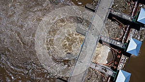 Aerial view of the water released from the concrete dam`s drainage channel as the overflow in the rainy season. Top view of turbi