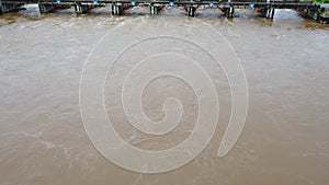 Aerial view of the water released from the concrete dam`s drainage channel as the overflow in the rainy season. Top view of turbid