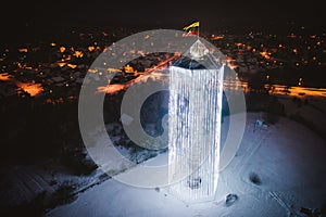 Aerial view of water tower decorated with Christmas lights and Lithuanian flag in Pasvalys city at night