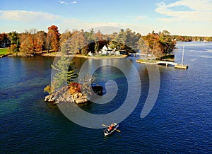 The aerial view of the waterfront residential area surrounded by striking fall foliage by St Lawrence River of Wellesley Island,