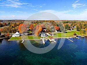 The aerial view of the waterfront residential area surrounded by striking fall foliage by St Lawrence River of Wellesley Island,