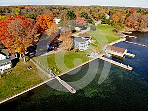 The aerial view of the waterfront residential area surrounded by striking fall foliage by St Lawrence River of Wellesley Island,