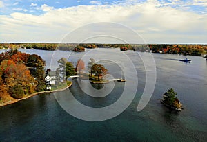 The aerial view of the waterfront residential area surrounded by striking fall foliage by St Lawrence River of Wellesley Island, photo