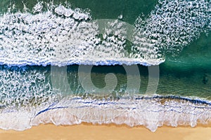 Aerial view of a wave breaking at the shore of the Comporta Beach.