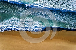 Aerial view of a wave breaking at the shore of the Comporta Beach in Portugal