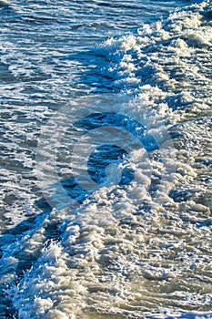 Aerial view of wave crushing along the shoreline