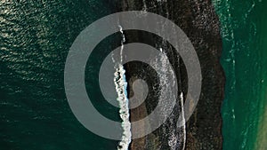 Aerial View of Waves Crashing Against Coral Reef Near Coastal Shoreline