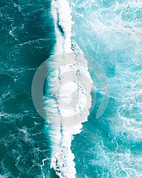 Aerial view of a waves crashing and rolling in the ocean