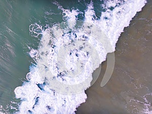 Aerial view of Waves crashing on sandy shore,Sea surface ocean waves background,Top view beach background