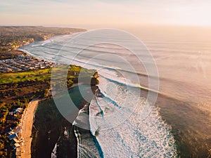 Aerial view of waves at warm sunset and sandy beach. Ocean wave in Bali