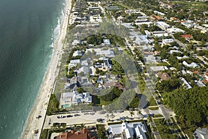 Aerial view of wealthy waterfront neighborhood. Expensive mansions between green palm trees on Gulf of Mexico shore in