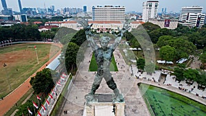 Aerial view of West Irian Liberation monument in downtown Jakarta with Jakarta cityscape. Jakarta, Indonesia, August 29, 2022