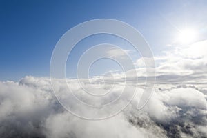 Aerial view white clouds in blue sky. View from drone. Aerial top view cloudscape. Texture of clouds. View from above. Sunrise or