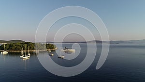 Aerial view of white luxury yacht and sailboats embarked in bay in Croatia, France, Greece, Ibiza, Italy, Europe.