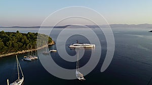 Aerial view of white luxury yachts and sailboats embarked in bay in Croatia, France, Greece, Ibiza, Italy, Europe.