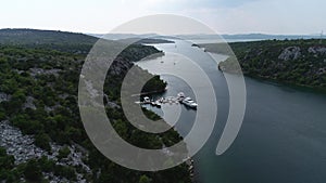Aerial view of white sailboats and yachts embarked in a marina or bay with turquoise, water. Croatia, Europe.