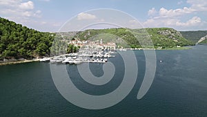 Aerial view of white sailboats and yachts embarked in a marina or bay with turquoise, water. Croatia, Europe.