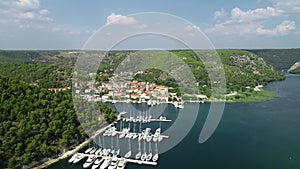 Aerial view of white sailboats and yachts embarked in a marina or bay with turquoise, water. Croatia, Europe.