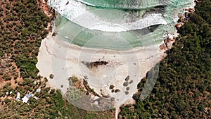 Aerial view of white sand beach, blue sea, marine vegetation,waves,trees and red rocks. abstract sea green shades coral