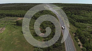 Aerial View of White Truck Passing Busy highway/ Highway Overpass/ Overdrive/ Bridge. Cars and trucks go on the road on