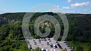 Aerial view of wild nature with rock clif and endless forest. Clip. Beautiful river along summer trees.