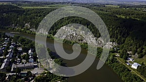 Aerial view of wild nature with rock clif and endless forest. Clip. Beautiful river along summer trees.