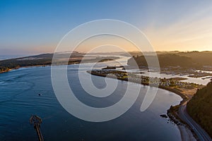 Aerial view of Winchester Bay Oregon with the Residential District, Harbor, Marina a large RV park and fishing boats.