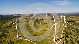 Aerial view of Wind Generating stations in green fields on a background of blue sky. Portugal.