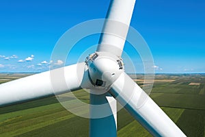 Aerial view of wind turbine rotor with blades on modern wind farm from drone pov