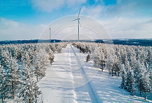 Aerial view Wind turbine in snow winter landscape in Finland. Alternative energy in winter