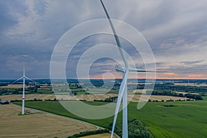 Aerial view of wind turbine with wheat and maize fields in summer. Aerial view of Eolian generator with agriculture fields in the