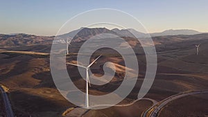 Aerial view of Wind Turbines generating green energy. Sunset and beautiful colours