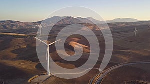 Aerial view of Wind Turbines generating green energy. Sunset and beautiful colours