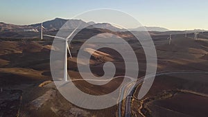 Aerial view of Wind Turbines generating green energy. Sunset and beautiful colours