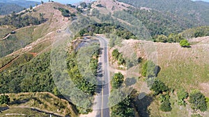 Aerial view of winding mountain road in the summer at Phrae, Thailand. Beautiful forest nature landscape with countryside road