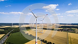 Aerial view of windmill against blue sky with clouds.