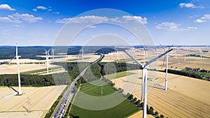 Aerial view of windmill against blue sky with clouds.