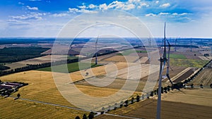 Aerial view of windmill against blue sky with clouds.