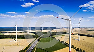 Aerial view of windmill against blue sky with clouds.