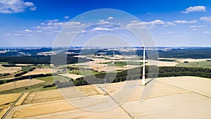 Aerial view of windmill against blue sky with clouds.