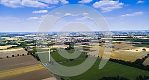 Aerial view of windmill against blue sky with clouds.