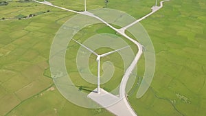 Aerial view windmill turbine on green field background. Wind power turbine generation on energy station drone view from