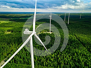 Aerial view of windmills in summer forest in Finland. Wind turbines for electric power with clean and Renewable Energy