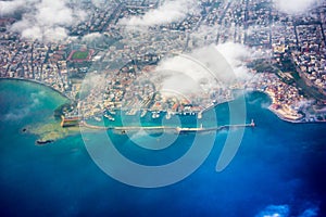 Aerial view through the window of an airplane of the beautiful city of Chania with it`s old harbor and the famous lighthouse.
