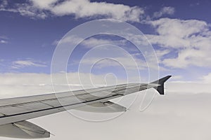 Aerial view of wing from jetplane blue sky and big white cloud background photo