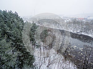 Aerial view of winter forest and ice drift on the river