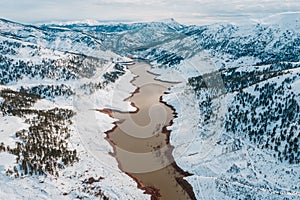 Aerial view of winter lake in snowy mountains