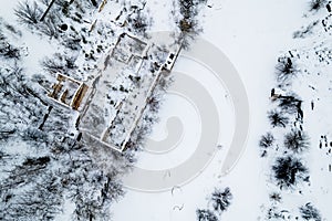 aerial view of the winter landscape of an abandoned building by a frozen river